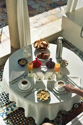 a table with breakfast foods and coffee on it at Riad Tizwa Marrakech in Marrakech