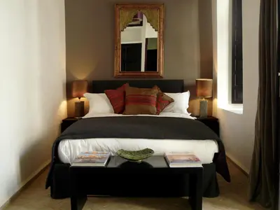 a bedroom with a bed and a table with books at Maison Manzano in Marrakech