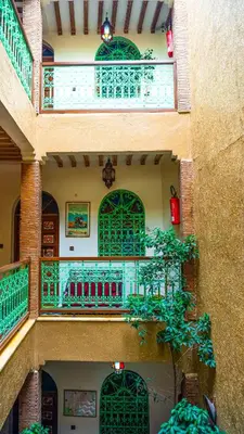 an external view of a building with green doors and a tree at Riad Taghazoute in Marrakech