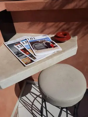 a table with a newspaper and a chair on it at Riad BILKIS in Marrakech