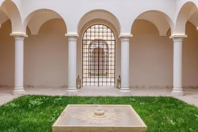 a fountain in the middle of a lawn with arches at Ksar Char-Bagh Small Luxury Hotels in Marrakech