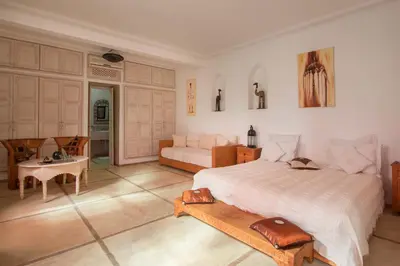 a bedroom with a bed and a table and a couch at Riad Alegria in Marrakech