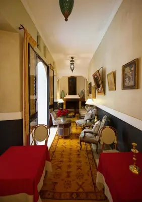 a living room with a red table and chairs at Riad Lyla in Marrakech