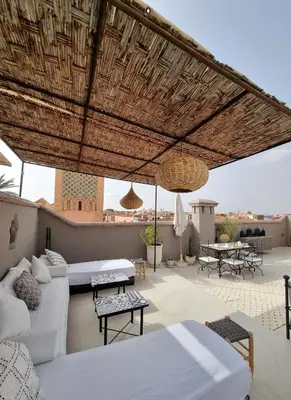 a patio with two beds and a couch and tables at Riad les Rêves d'Amélie in Marrakech