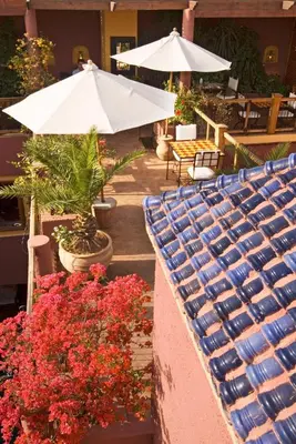 a patio with a bunch of flowers and umbrellas at Riad Noga in Marrakech