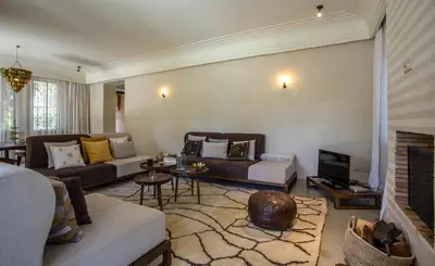 a living room with a couch and a tv at Villa Atlas de Luxe avec piscine privée Domaine des Kasbahs in Marrakech