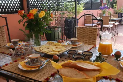 a table with a breakfast of bread and orange juice at Riad Dar Zampa in Marrakech