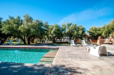 a pool with chairs and a table and trees at SA FONDA in Tameslouht