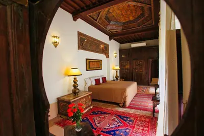 a bedroom with a bed and a table with a vase of flowers at Riad du Ciel Marrakech in Marrakech