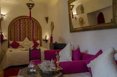 a room with a bed and a couch and a mirror at Riad Anabel in Marrakech