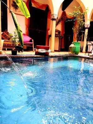 a large swimming pool with a fountain in a house at Riad Rêve d Antan in Marrakech