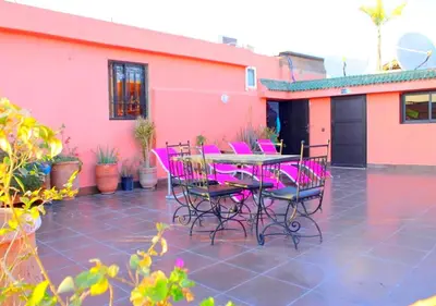 a patio with a table and chairs in front of a house at Miramare Marrakech in Marrakech