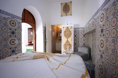 a bedroom with two beds with blue and white tiles at Riad O LY in Marrakech