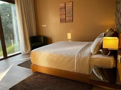 a bedroom with a bed and a large window at Palms Edge Villas avec Piscine & Jardin Privés in Marrakech