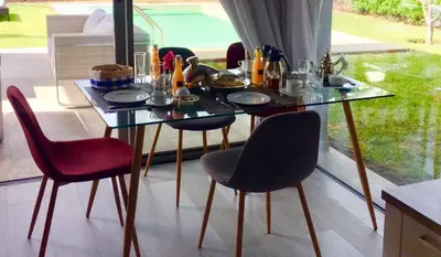 a dining room table with chairs and food on it at Palms Edge Villas avec Piscine & Jardin Privés in Marrakech