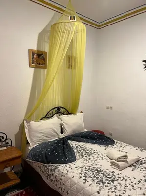 a bedroom with a bed with a curtain above it at Riad Mahjouba Marrakech & SPA in Marrakech