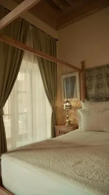 a bedroom with a canopy bed with a window at Riad Azoulay in Marrakech
