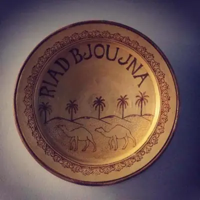 a plate with a picture of camels and palm trees at Riad Bjoujna in Marrakech