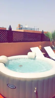 a hot tub on the roof of a building at Riad Bjoujna in Marrakech