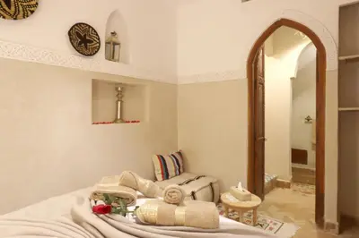 a bedroom with a bed with a mirror and a sink at Riad Venezia in Marrakech
