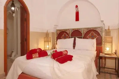 a bedroom with a bed with red pillows on it at Riad Venezia in Marrakech