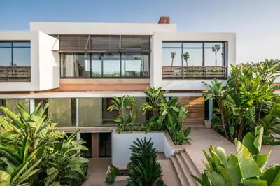 an exterior view of a house with palm trees at Zagora and Marhba villas Marrakech - by EMERALD STAY in Marrakech