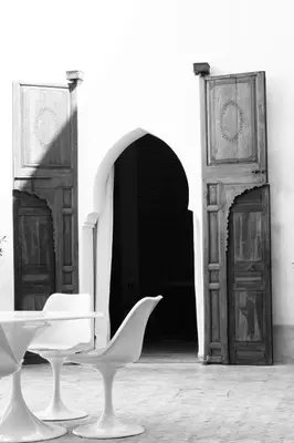 a white chair and a table in front of a door at Riad UP in Marrakech