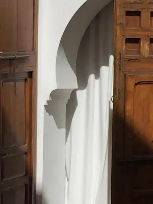 an open door with a shadow on a wall at Riad UP in Marrakech