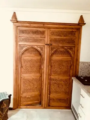 a wooden door in the corner of a room at Stylish Moroccan Apartment Gueliz City Centre in Marrakech