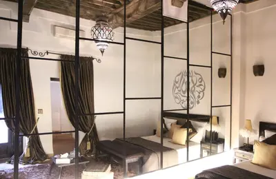 a bedroom with a bed with a mirrored wall at Riad Terra Bahia in Marrakech