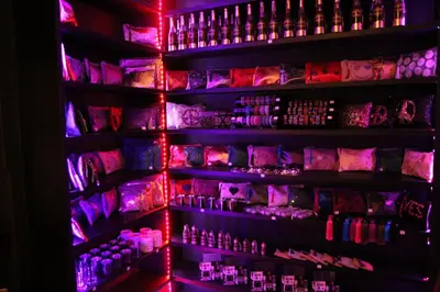 a shelf of bottles in a bar with red lights at Riad Terra Bahia in Marrakech