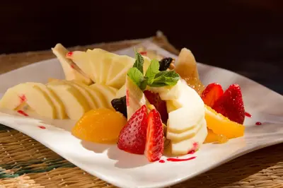 a white plate topped with fruit on a table at Oasis lodges in Marrakech
