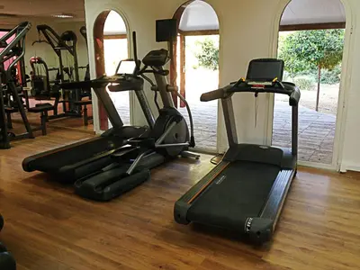 a gym with several treadmills and exercise bikes at Oasis lodges in Marrakech