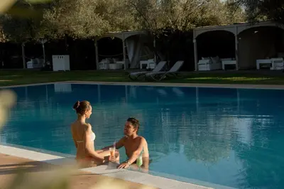 a man and a woman sitting in a swimming pool at Oasis lodges in Marrakech