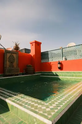 a pool of water in front of a building at Riad Orange in Marrakech