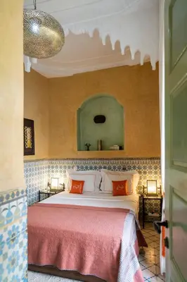 a bedroom with a large bed with orange pillows at Riad Orange in Marrakech
