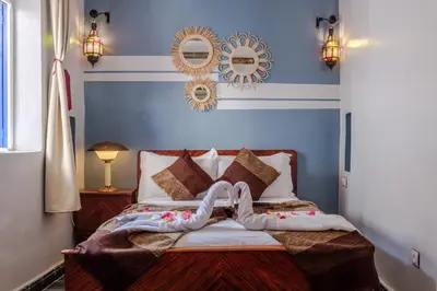 a bedroom with blue walls and a bed with a person laying on it at Riad Bobby Marrakech in Marrakech