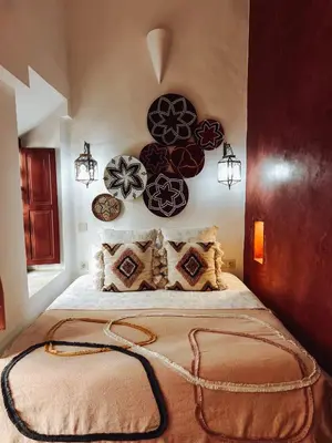 a bedroom with a large bed with decorative plates on the wall at DAR AURORA in Marrakech