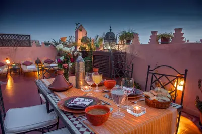 a table with food and wine glasses on a patio at Riad Sable Chaud in Marrakech