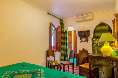 a living room with a table and chairs at Riad Sable Chaud in Marrakech