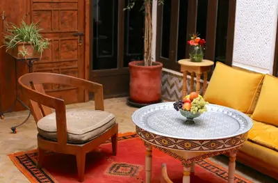 a living room with a table with a bowl of fruit on it at Riad Ambre et Jasmin in Marrakech