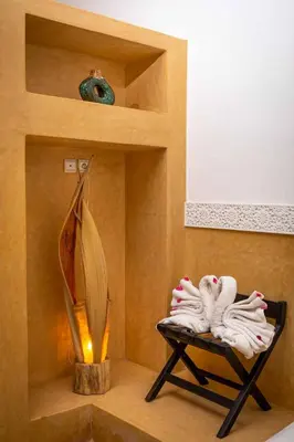 a bathroom with a shelf with towels and a lamp at Riad Ambre et Jasmin in Marrakech