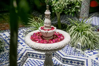 a bird bath with flowers in a garden at Riad Bab Chems in Marrakech