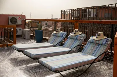 three chairs sitting on top of a balcony at Riad Bab Chems in Marrakech