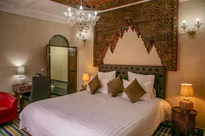 a bedroom with a large white bed with pillows at Riad Bab Chems in Marrakech
