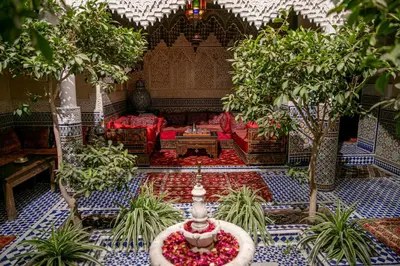 a living room with a red couch and a fountain at Riad Bab Chems in Marrakech