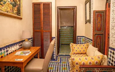 a living room with a chair and a table and a shower at Riad Bab Chems in Marrakech
