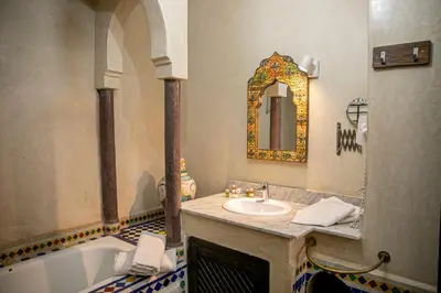 a bathroom with a sink and a tub and a mirror at Riad Bab Chems in Marrakech