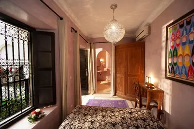 a bedroom with a bed and a window at Riad des trois palais in Marrakech