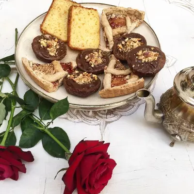 a plate of pastries and bread on a table with roses at Riad Palacio De Las Especias in Marrakech